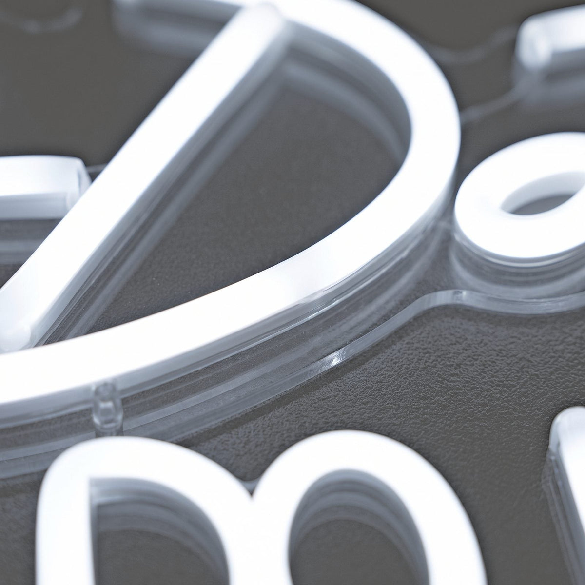 Close-up of glowing white neon LED lettering mounted on clear acrylic against a soft grey background