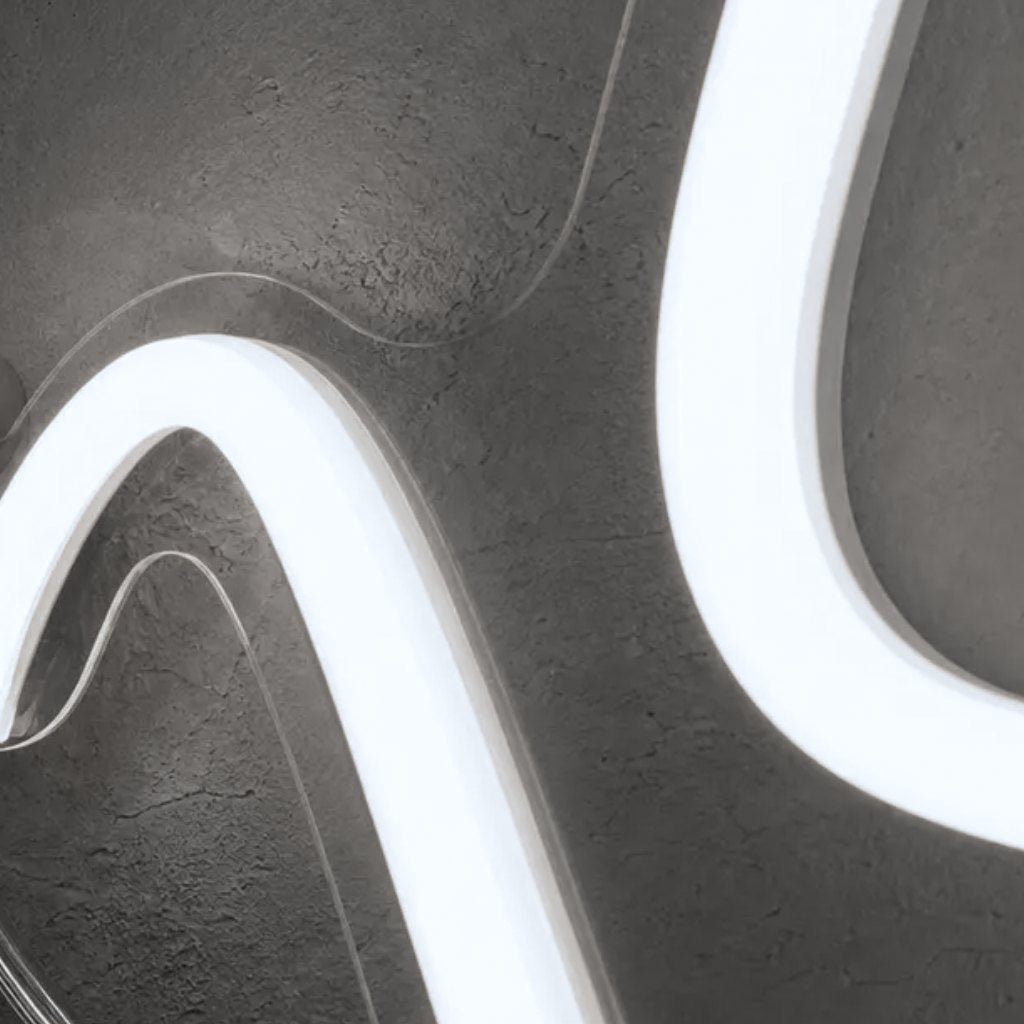 Close-up of clear acrylic cut closely around curving cool white neon LED tubes