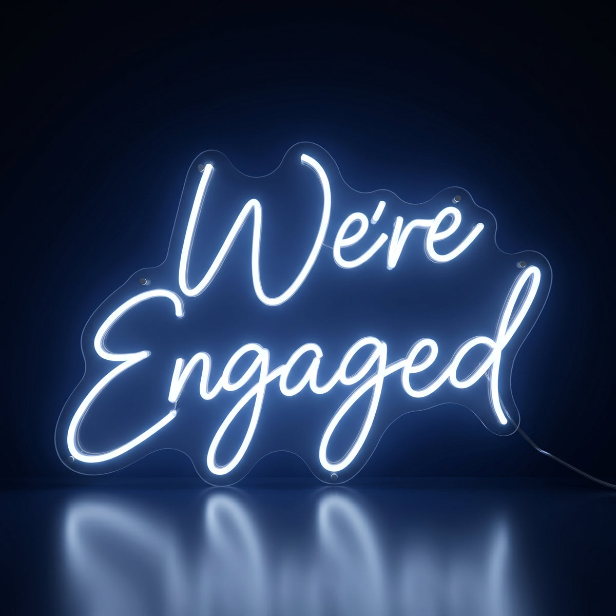 We're Engaged white LED neon sign glowing in a dark room